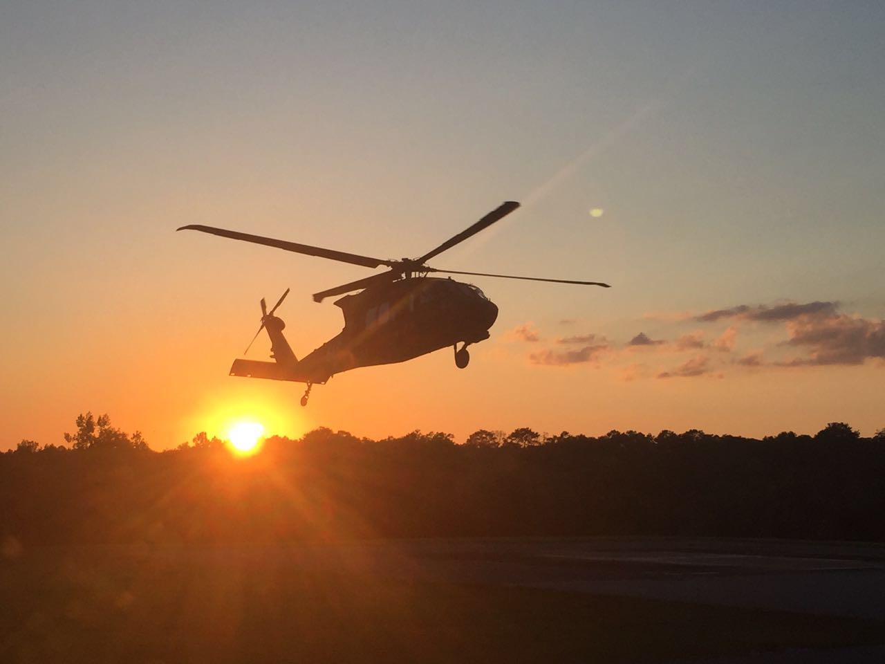 Black Hawk silueteado contra el sol al atardecer